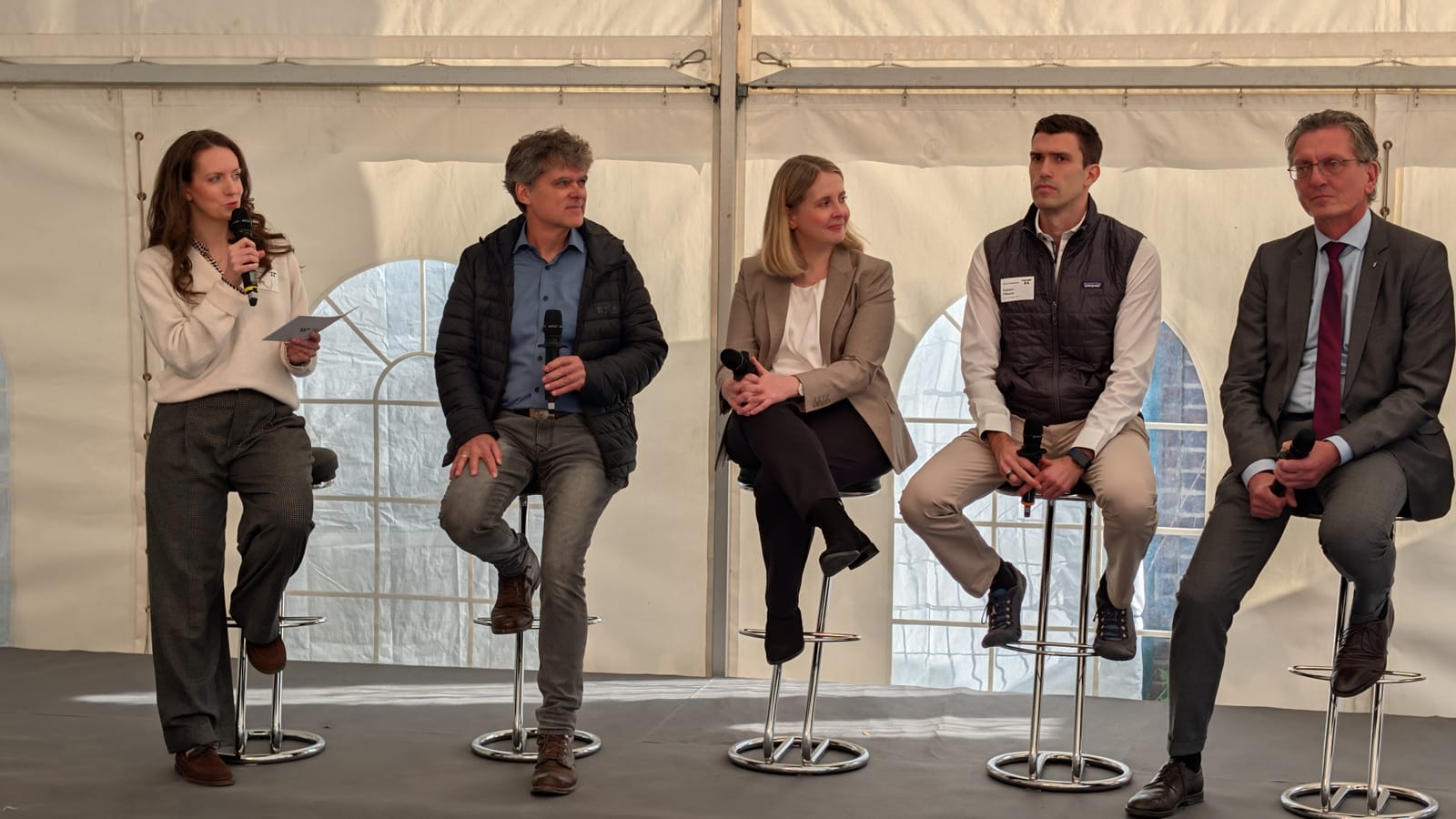 Von links: Miriam Anna Umhauer (Moderation), Dipl.-Ing. Ronald Meyer, Bundesbauministerin Verena Hubertz, Robert Pflaum (Terra Immobilien GmbH) und Berlins Bausenator Christian Gaebler auf dem Podium im Zelt